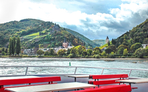 Rhine Valley view with hills and village from a boat during Frankfurt day trip.