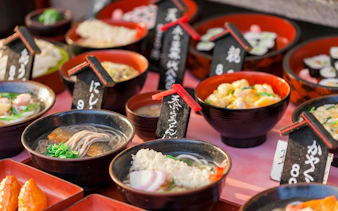 Bowls of traditional Japanese dishes displayed at a food market in Kyoto, Japan.