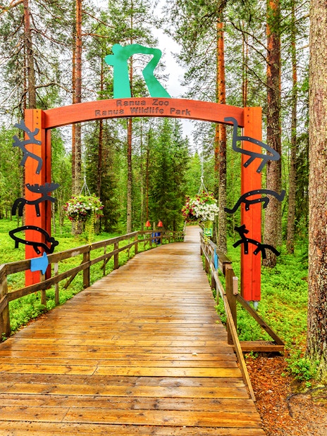 Ranua Wildlife Park entrance with wooden walkway and forest backdrop.