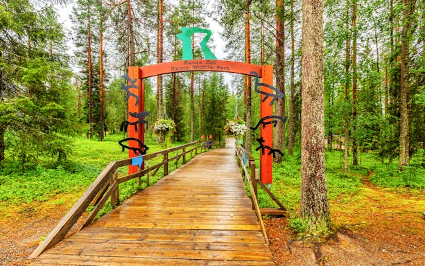 Ranua Wildlife Park entrance with wooden walkway and forest backdrop.