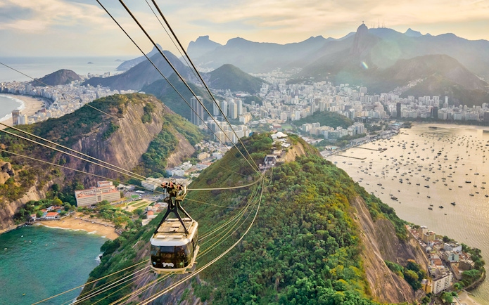 Cable car descending from Sugarloaf Mountain, Rio de Janeiro, with city and ocean views.