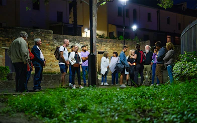 Group of people on a nighttime guided tour in Sydney, discussing true crime stories.