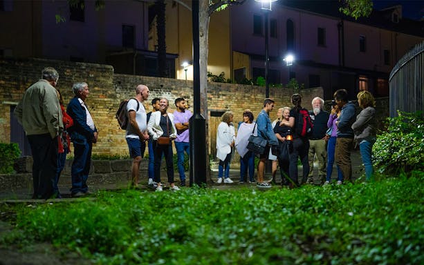 Group of people on a nighttime guided tour in Sydney, discussing true crime stories.