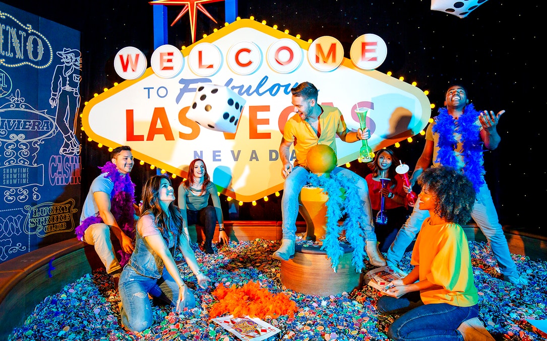 Guests enjoying interactive exhibit at Madame Tussauds Las Vegas with iconic sign and dice.