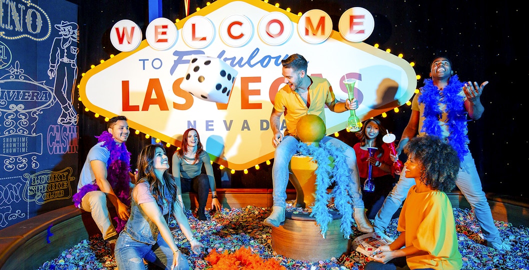 Guests enjoying interactive exhibit at Madame Tussauds Las Vegas with iconic sign and dice.