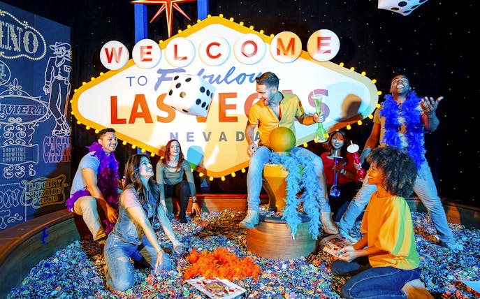 Guests enjoying interactive exhibit at Madame Tussauds Las Vegas with iconic sign and dice.