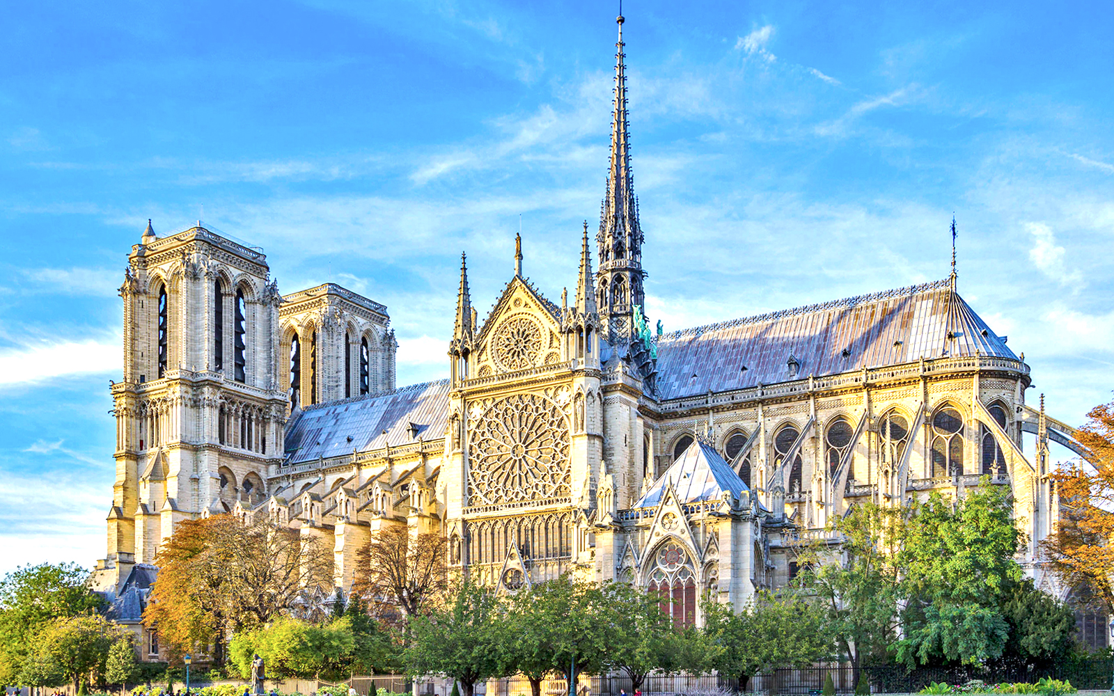 Notre-Dame Cathedral facade with tourists using audio guides in Paris.