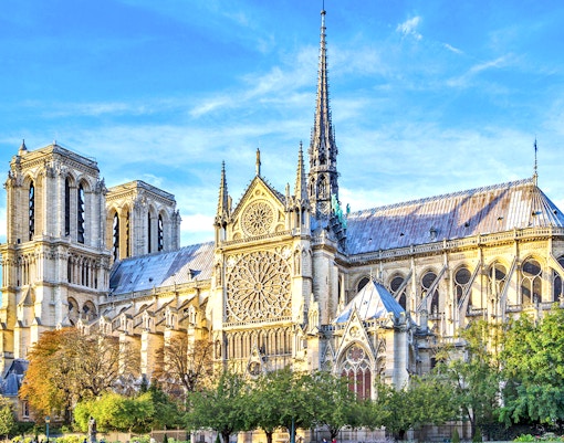 Notre-Dame Cathedral facade with tourists using audio guides in Paris.