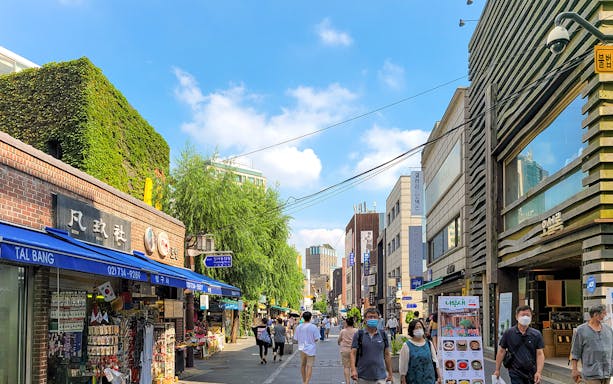 Seoul street with shops and pedestrians, part of a full-day guided tour.