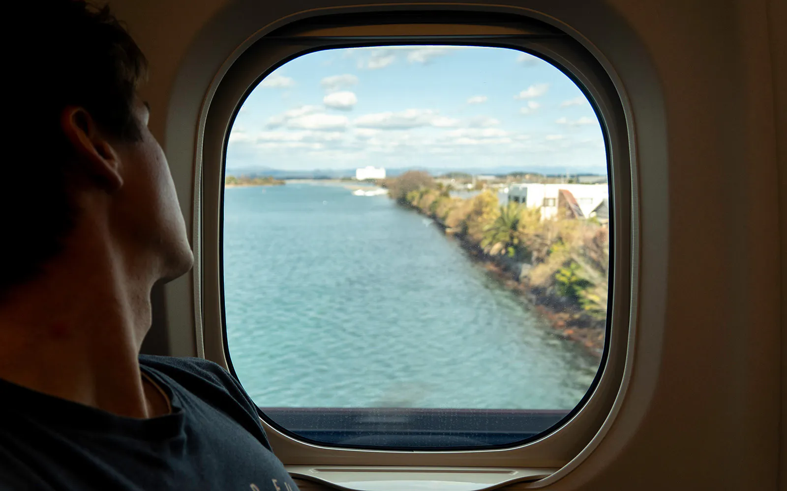 View of a river and landscape through a bullet train window.