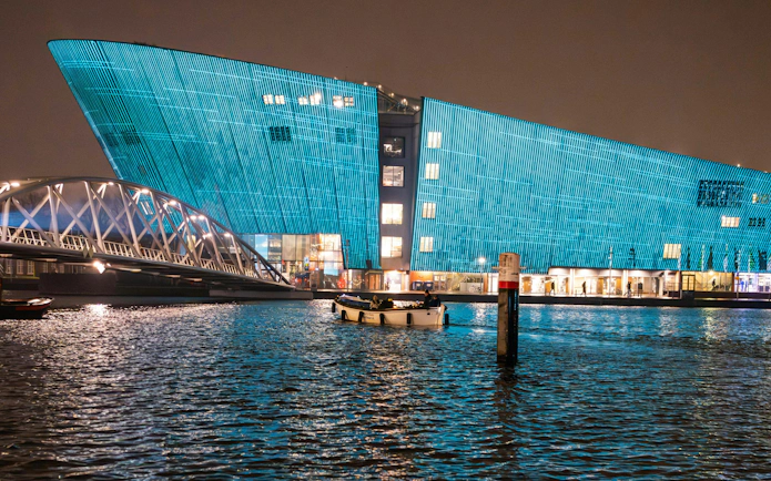 Amsterdam Light Festival, illuminated building and bridge over canal at night.