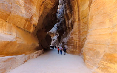 Tourists walking through the Siq canyon leading to Al Khazneh in Petra, Jordan.