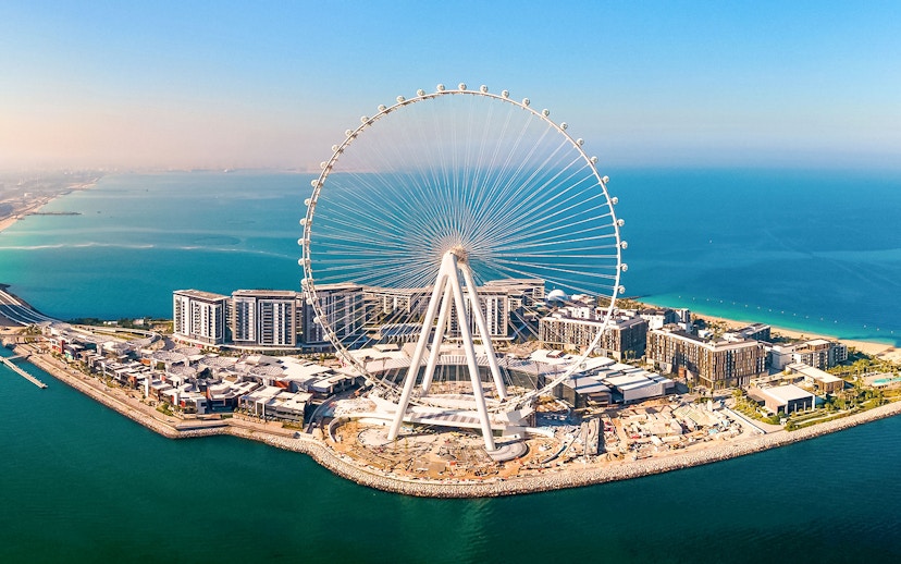 Ain Dubai Ferris wheel on Bluewaters Island, Dubai, UAE, with surrounding buildings and coastline.