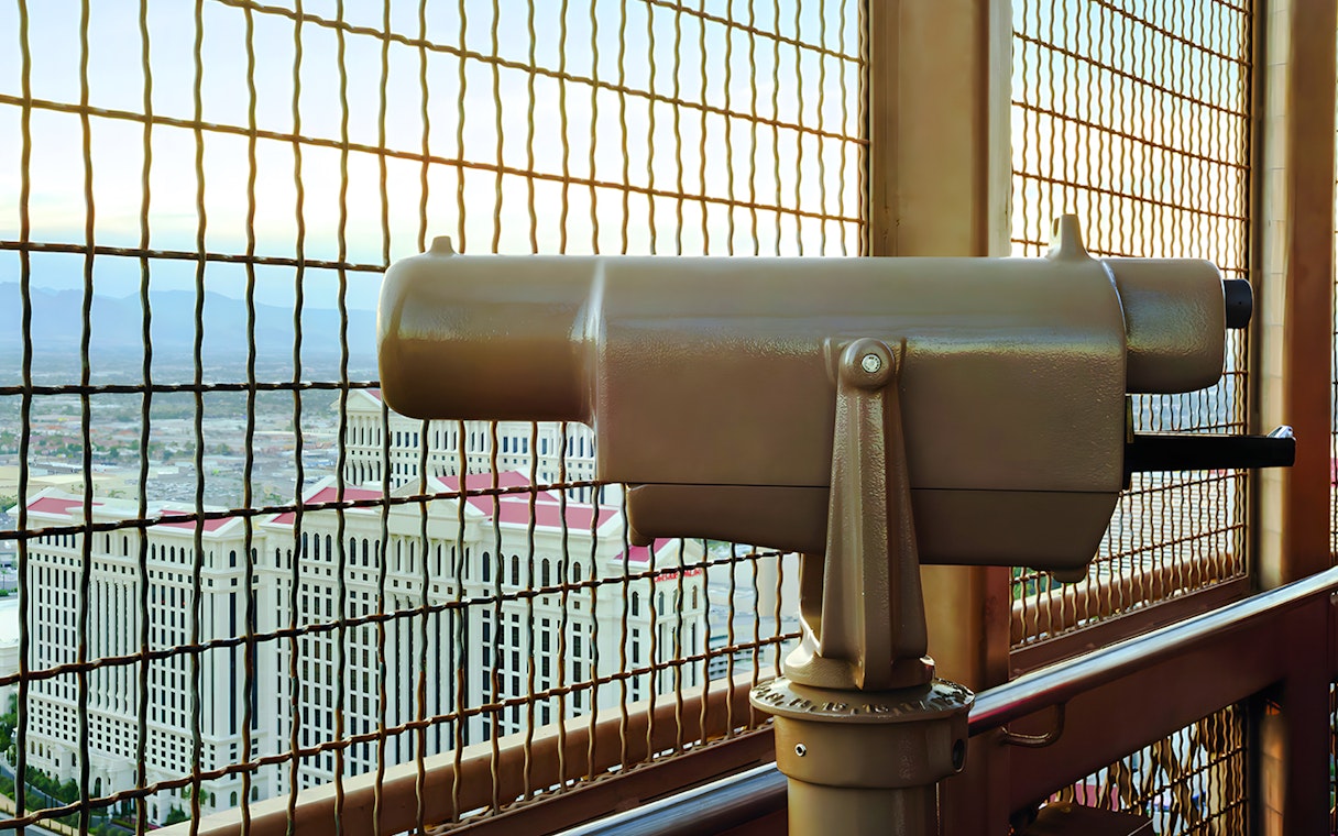 Viewing platform telescope at Eiffel Tower, Paris Las Vegas with cityscape in background.