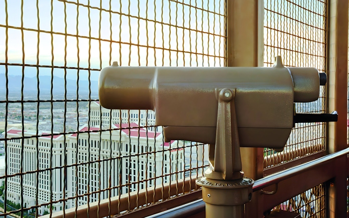Viewing platform telescope at Eiffel Tower, Paris Las Vegas with cityscape in background.