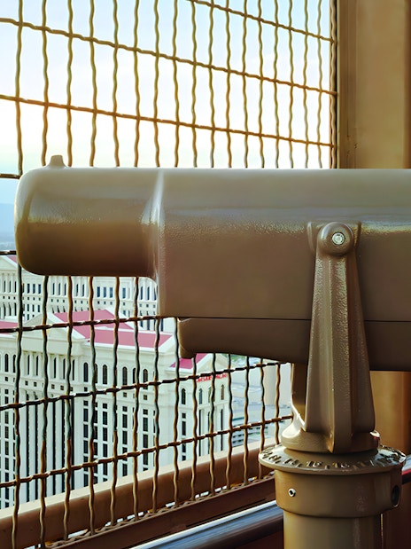 Viewing platform telescope at Eiffel Tower, Paris Las Vegas with cityscape in background.