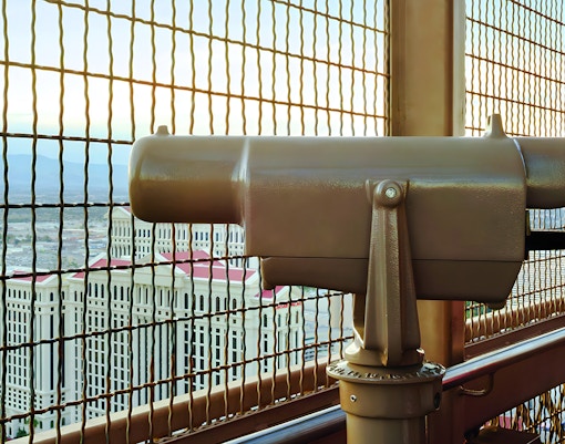 Viewing platform telescope at Eiffel Tower, Paris Las Vegas with cityscape in background.