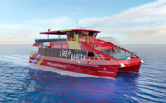 Red sightseeing boat on Malta's waters for hop-on hop-off tour.