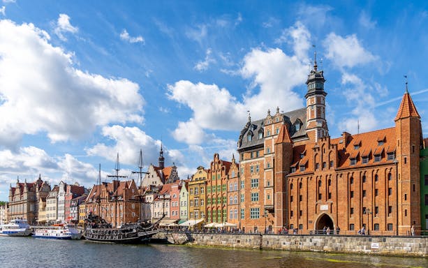 Colorful historic buildings along the Motława River in Gdańsk, Poland.