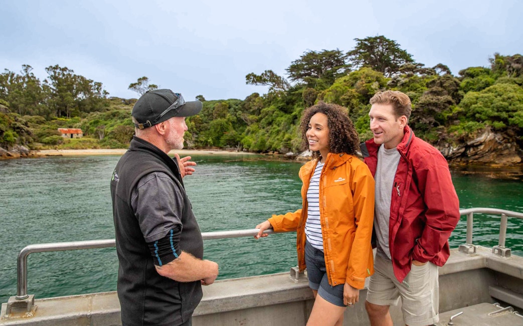 Tour guide explaining Ulva Island's features to visitors on a boat.