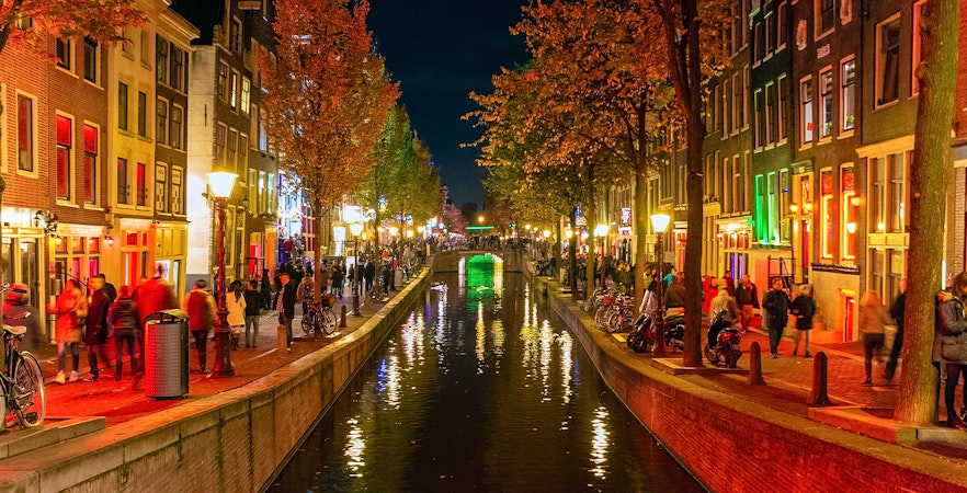 Amsterdam's Red Light District canal view with historic buildings and boats.