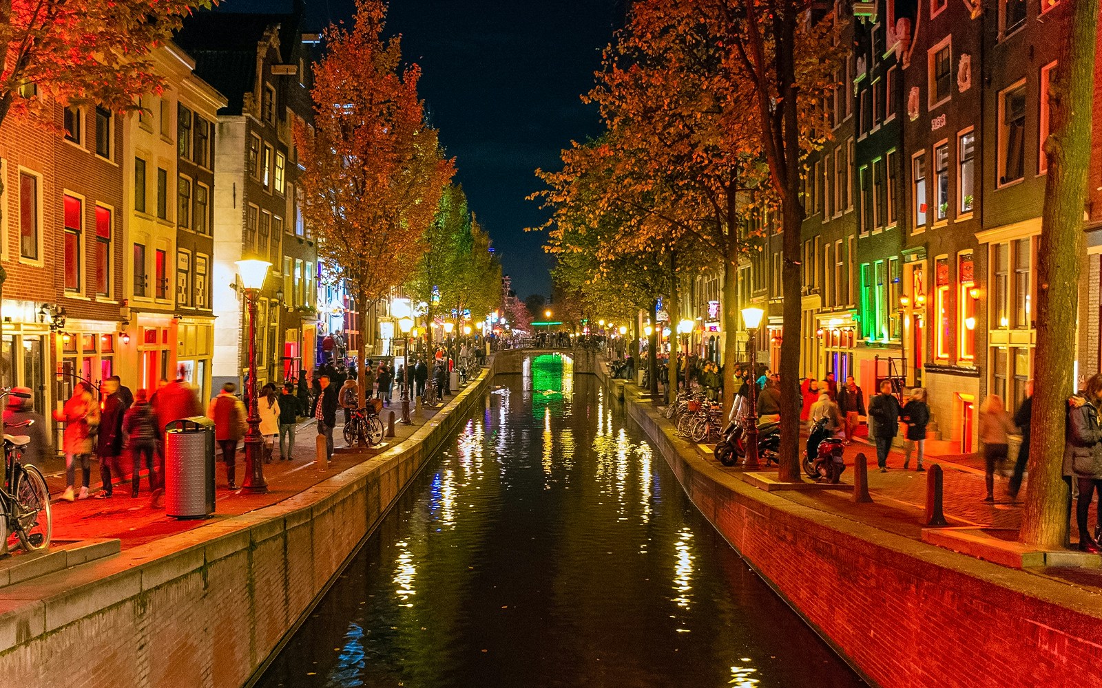Amsterdam's Red Light District canal view with historic buildings and boats.