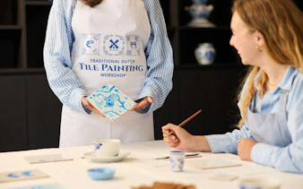 Guests participating in a Dutch blue tile painting workshop, creating traditional designs.