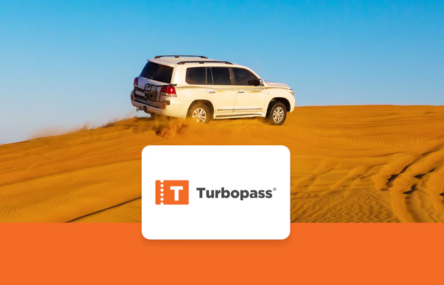 SUV driving on Dubai desert dunes, part of Dubai City Pass experience.