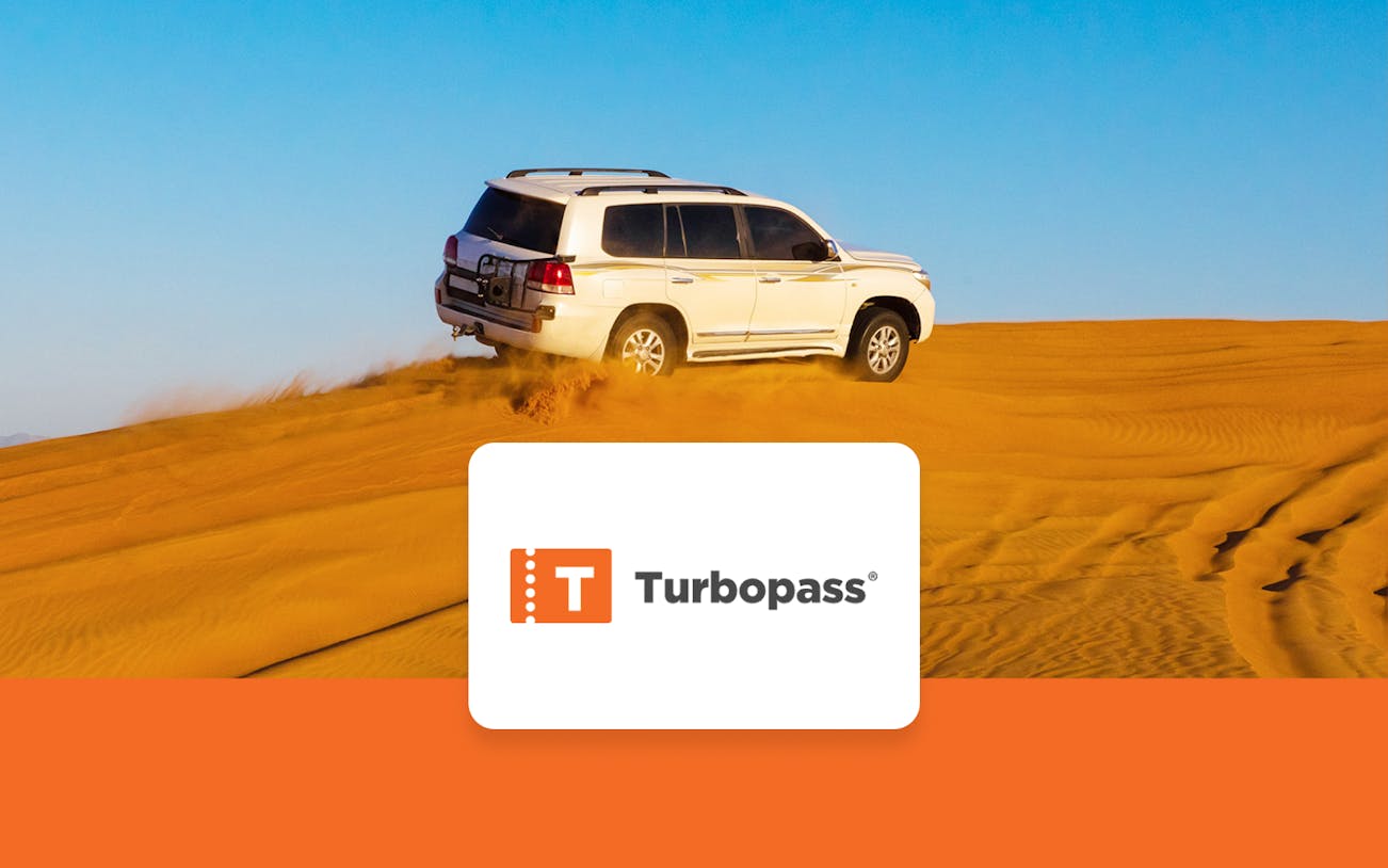 SUV driving on Dubai desert dunes, part of Dubai City Pass experience.