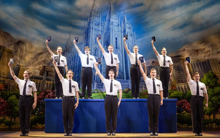 Cast performing The Book of Mormon on stage in Sydney with a backdrop of a temple.
