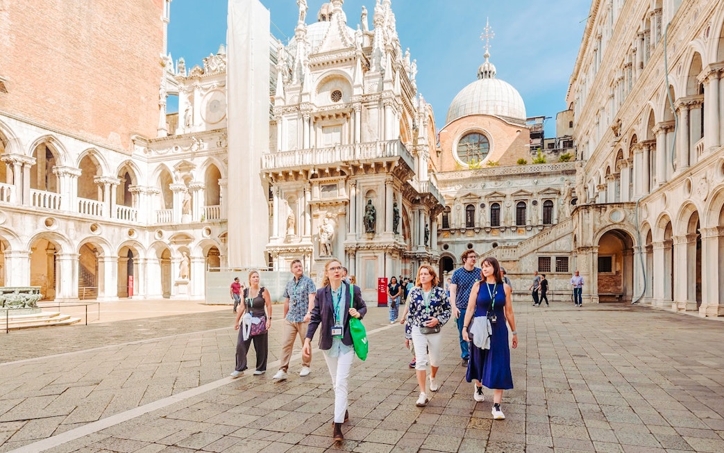 Visitors exploring the courtyard of Doge's Palace on a guided tour in Venice.