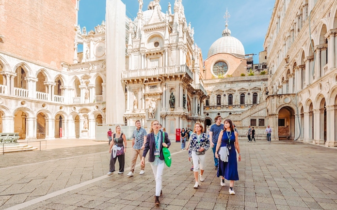 Visitors exploring the courtyard of Doge's Palace on a guided tour in Venice.