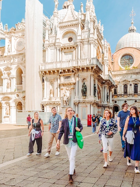 Visitors exploring the courtyard of Doge's Palace on a guided tour in Venice.