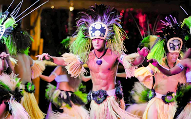 Dancers in traditional attire performing at Luau Kalamaku, Hawaii.
