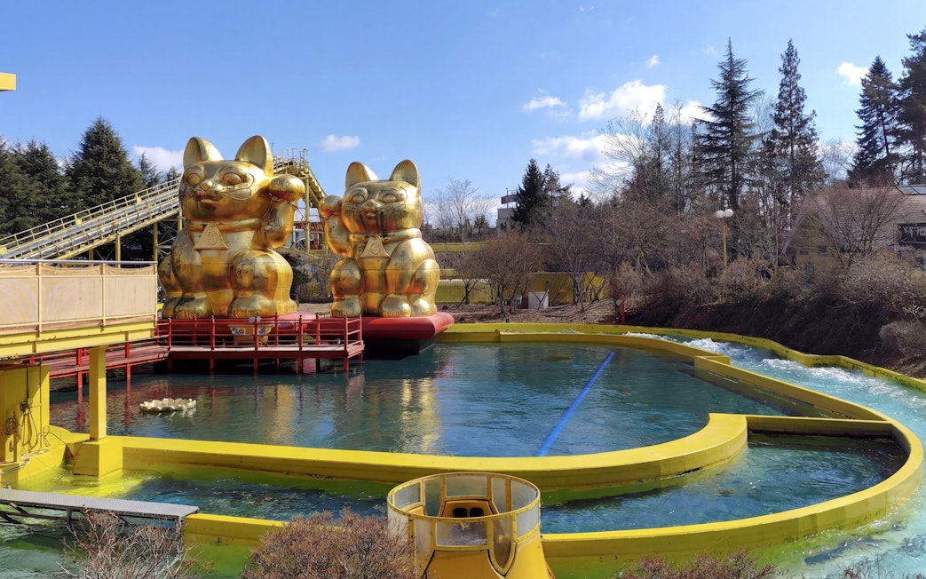 Nagashimasuka water ride with golden cat statues at Fuji-Q Highland, Japan.