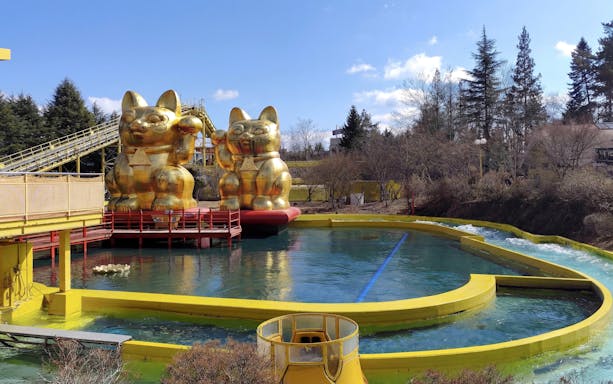 Nagashimasuka water ride with golden cat statues at Fuji-Q Highland, Japan.
