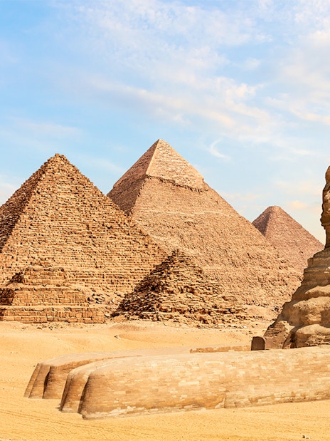 Pyramids of Giza and Great Sphinx under clear sky in Giza, Egypt.