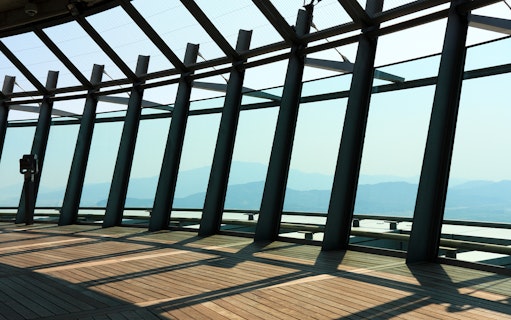 Observation deck view from Macau Tower with mountains in the background.