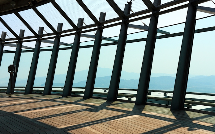 Observation deck view from Macau Tower with mountains in the background.