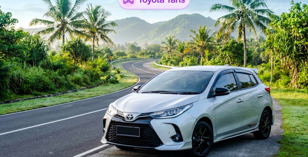 Toyota Yaris parked on a scenic road in Bali with palm trees and mountains.