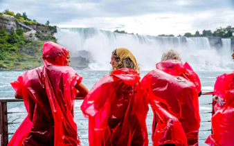 Visitors in red ponchos view Niagara Falls from a boat cruise in Canada.