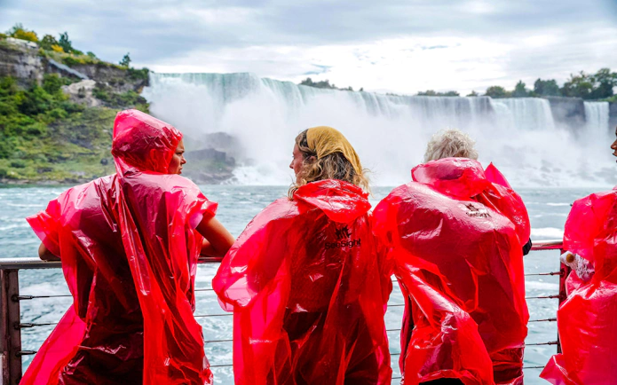 Visitors in red ponchos view Niagara Falls from a boat cruise in Canada.