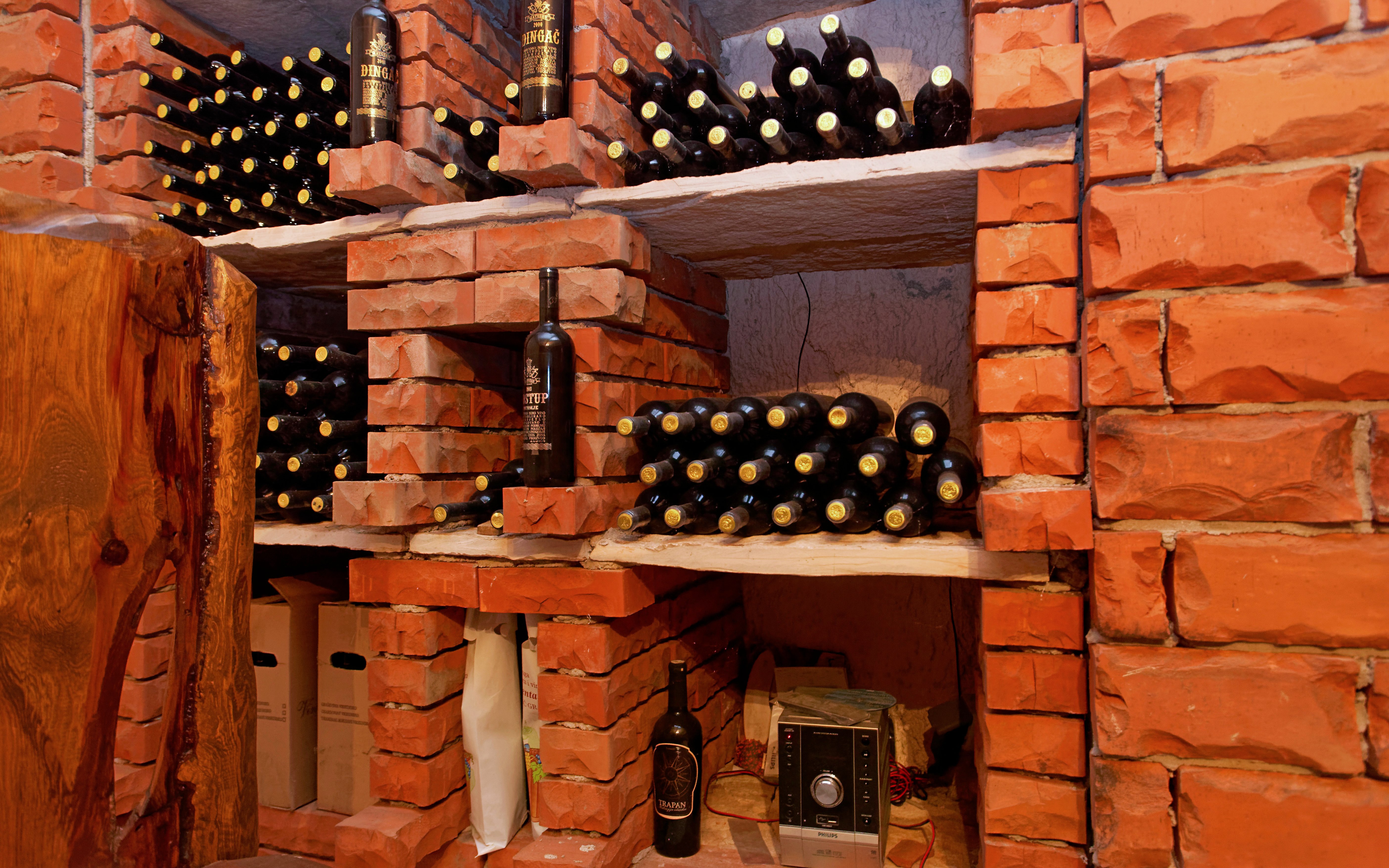 Wine bottles stacked in a brick cellar on Peljesac, Croatia.