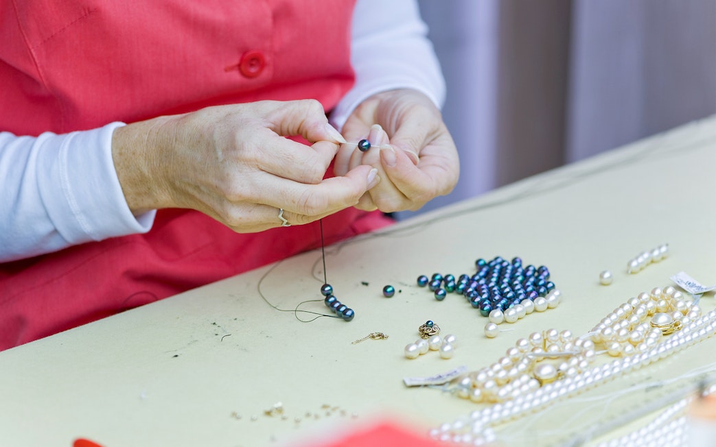 Stringing pearls and beads during Mallorca Caves of Drach excursion from Palma Port.