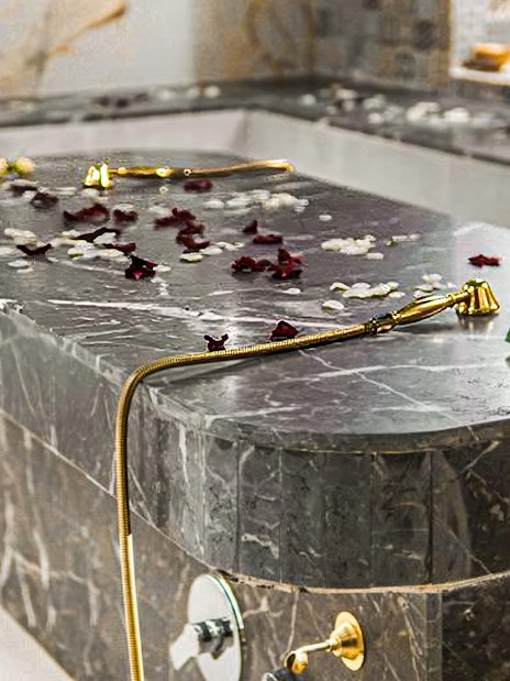Hammam spa table with rose petals and gold shower head.