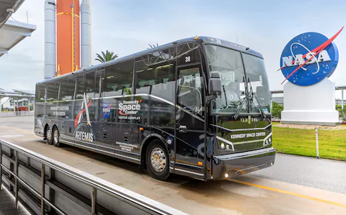 Kennedy Space Center tour bus near NASA sign, Orlando, Florida.