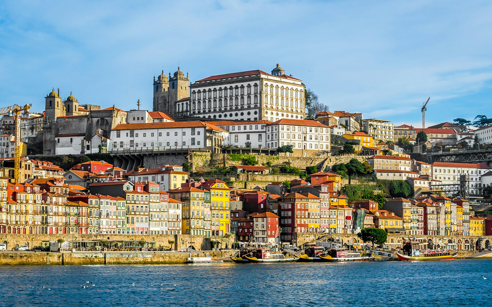 Porto cityscape with colorful buildings and bishop’s palace viewed from Douro River.