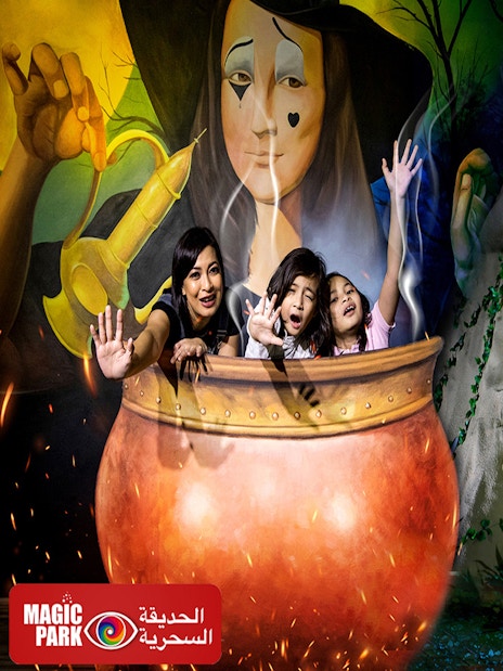 Visitors in a cauldron at Dubai Garden Glow's Dinosaur Park with dinosaur sculpture.