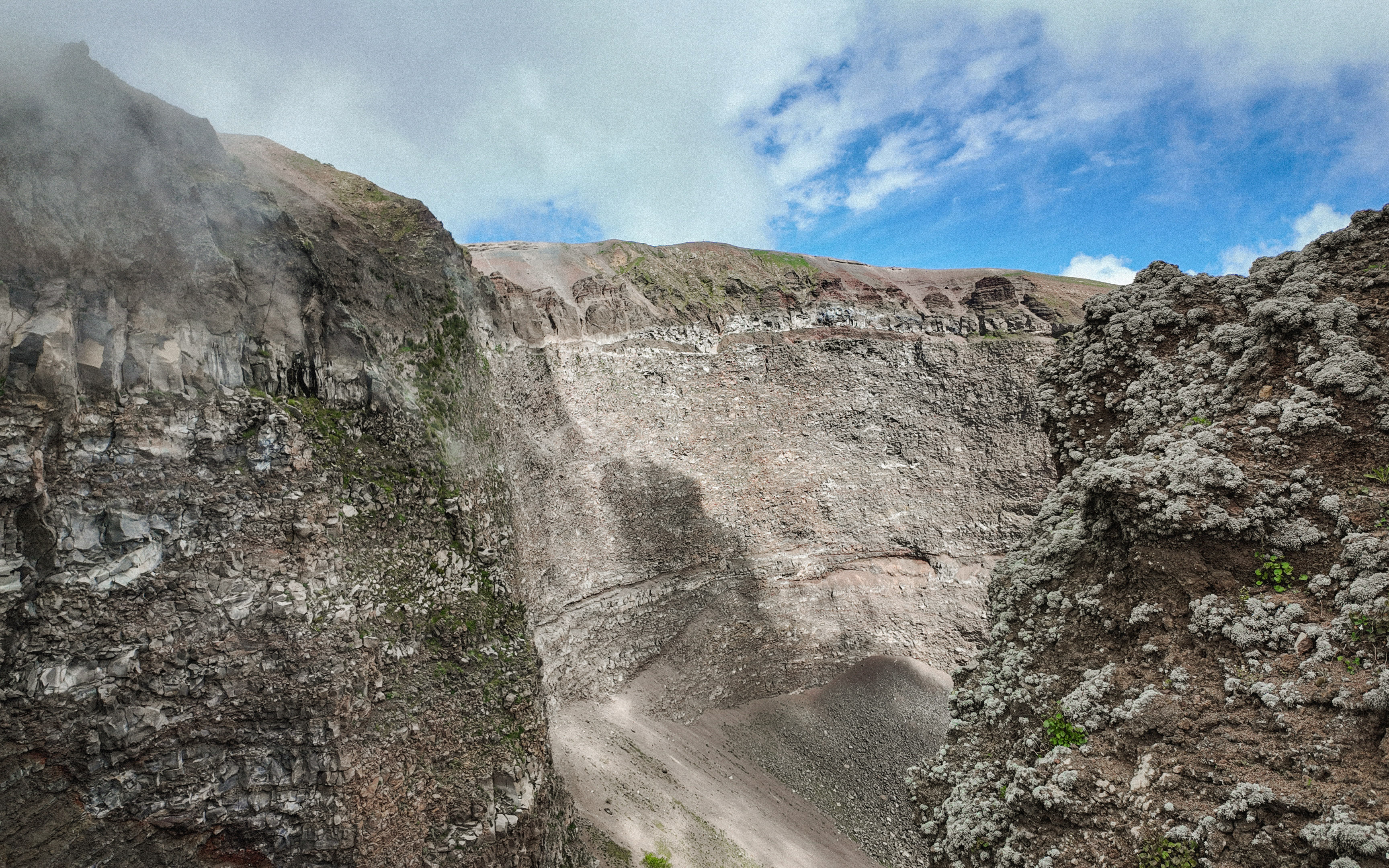 Crater of Mount Vesuvius with rocky walls and clear sky above.