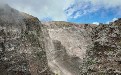 Crater of Mount Vesuvius with rocky walls and clear sky above.